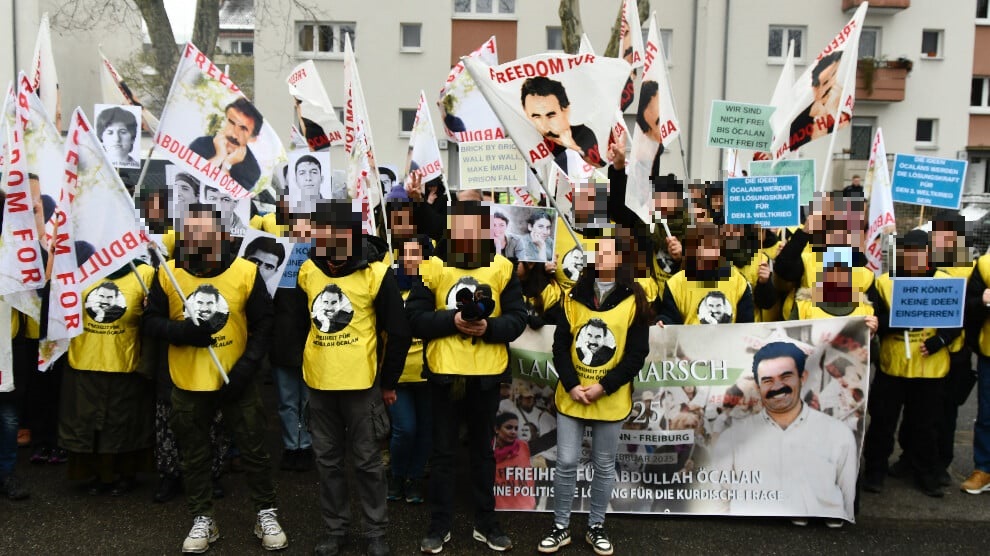 Jugendliche Teilnehmende des „Langen Marschs“ tragen Leibchen und Fahnen mit dem Abbild des PKK-Gründers ÖCALAN. Dies verdeutlicht den Führerkult um ÖCALAN, der trotz seiner Inhaftierung vor mehr als 25 Jahren bis heute andauert.